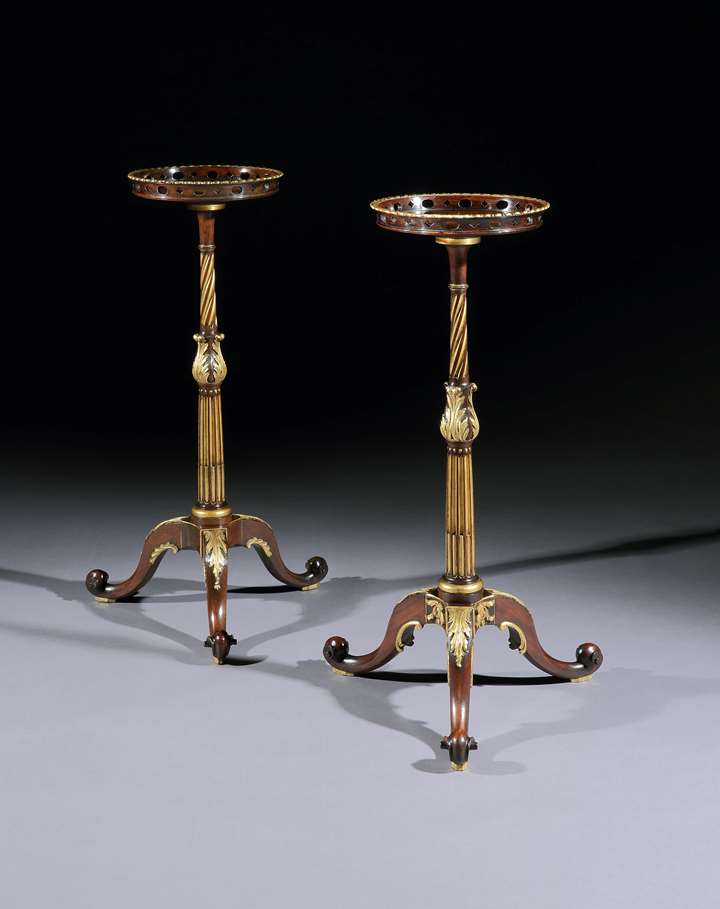 A near pair of parcel gilt mahogany torchères